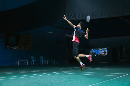 Intermediate badminton player mid-rally on indoor court — tips and racquet upgrades to level up your game